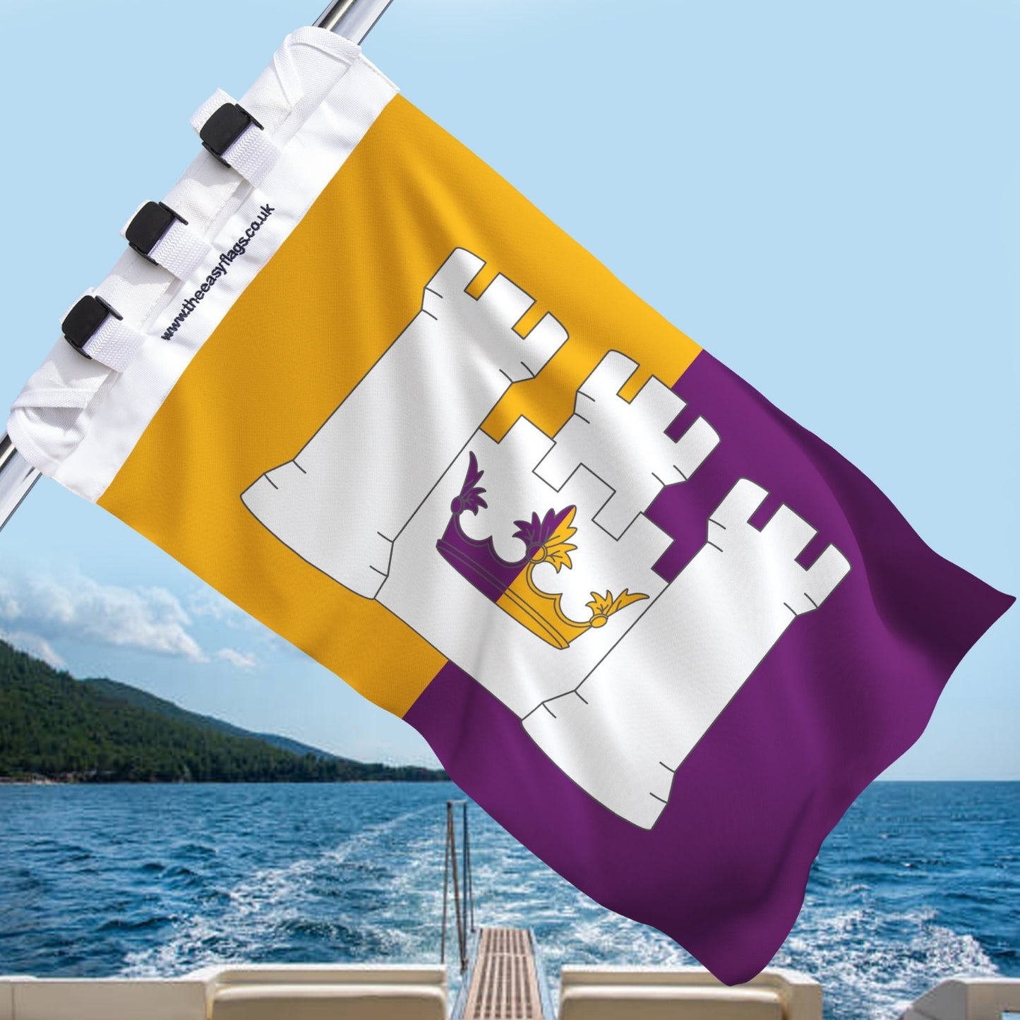 Aberdeenshire county flag with gold and purple background, featuring a white triple-towered castle and crown emblem, mounted on a boat rail with a universal triple-lock system, flying at sea with blue sky and coastline in the background