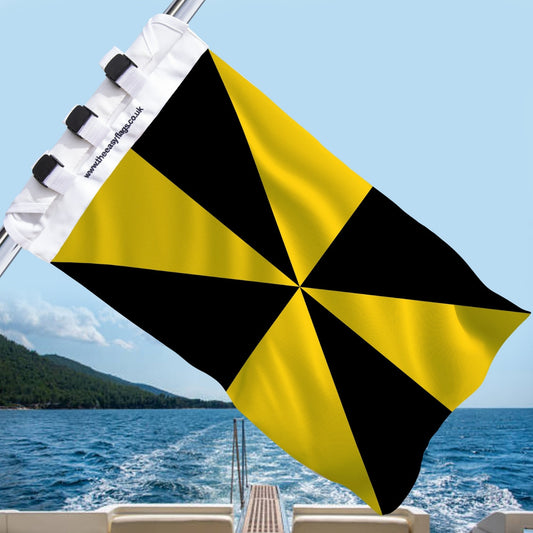 Argyll and Bute county flag with bold alternating yellow and black triangular segments in a radial pattern, mounted on a boat rail with a universal triple-lock system, flying at sea with blue sky and coastline in the background