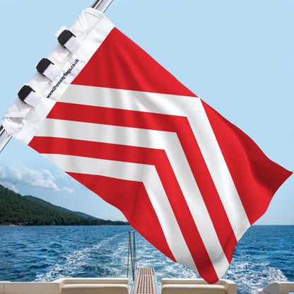 Glamorgan county flag with white chevrons, mounted on a boat rail with a universal triple-lock system, flying at sea with blue sky and coastline in the background