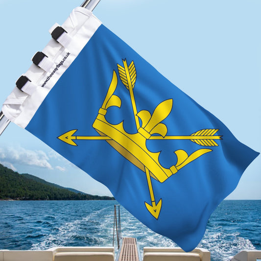 Suffolk county flag with blue background and golden crown pierced by two arrows, mounted on a boat rail with a universal triple-lock system, flying at sea with blue sky and coastline in the background